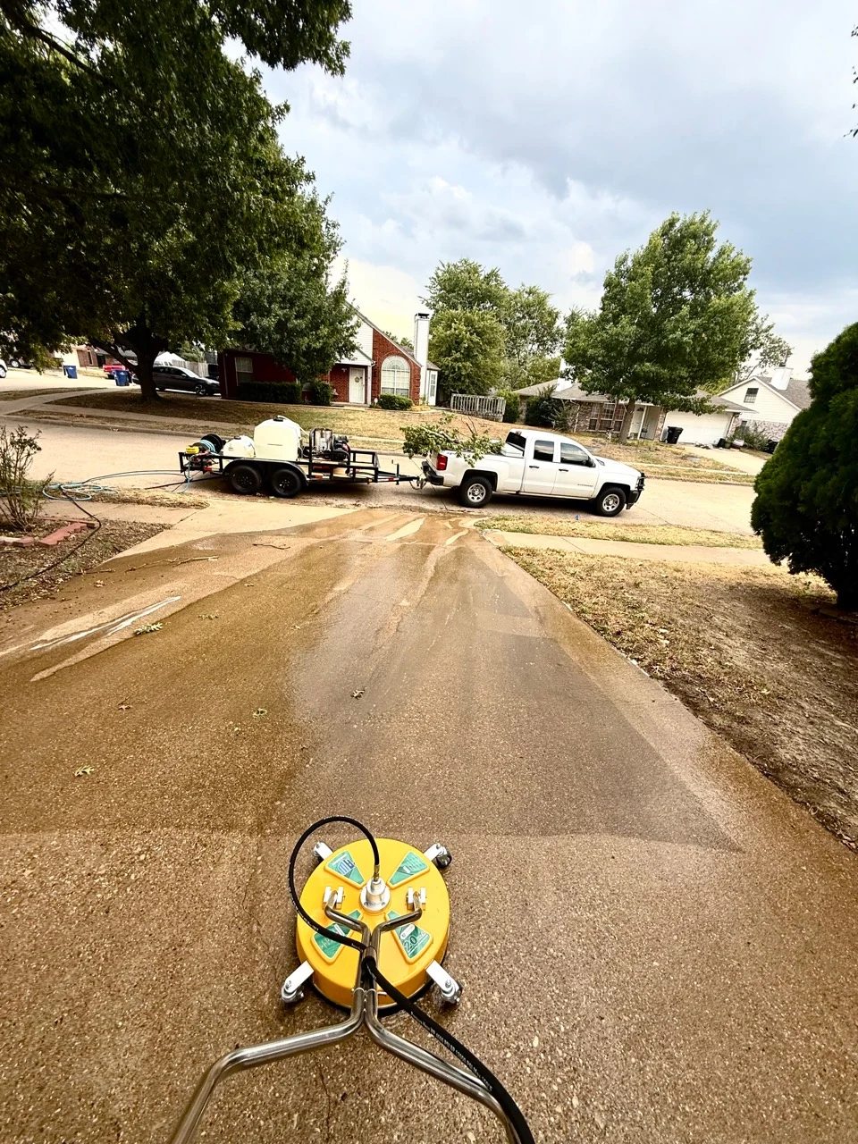 KT Exterior Services pressure washing equipment working on a residential driveway